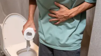 Muž drží v ruce toaletní papír a stiská si břicho.